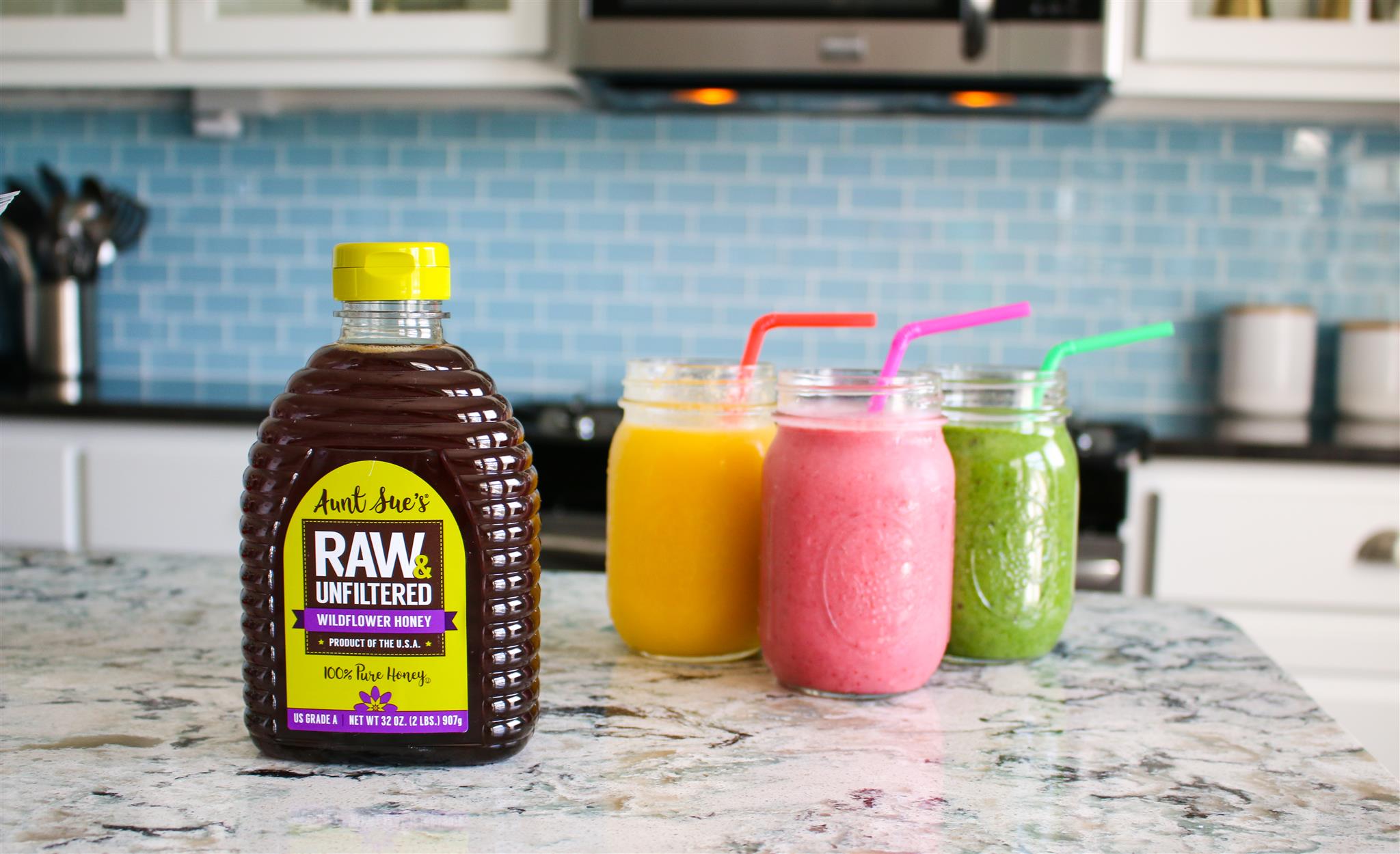 Aunt Sue's Raw & Unfiltered Honey with Fruit Smoothies on Counter